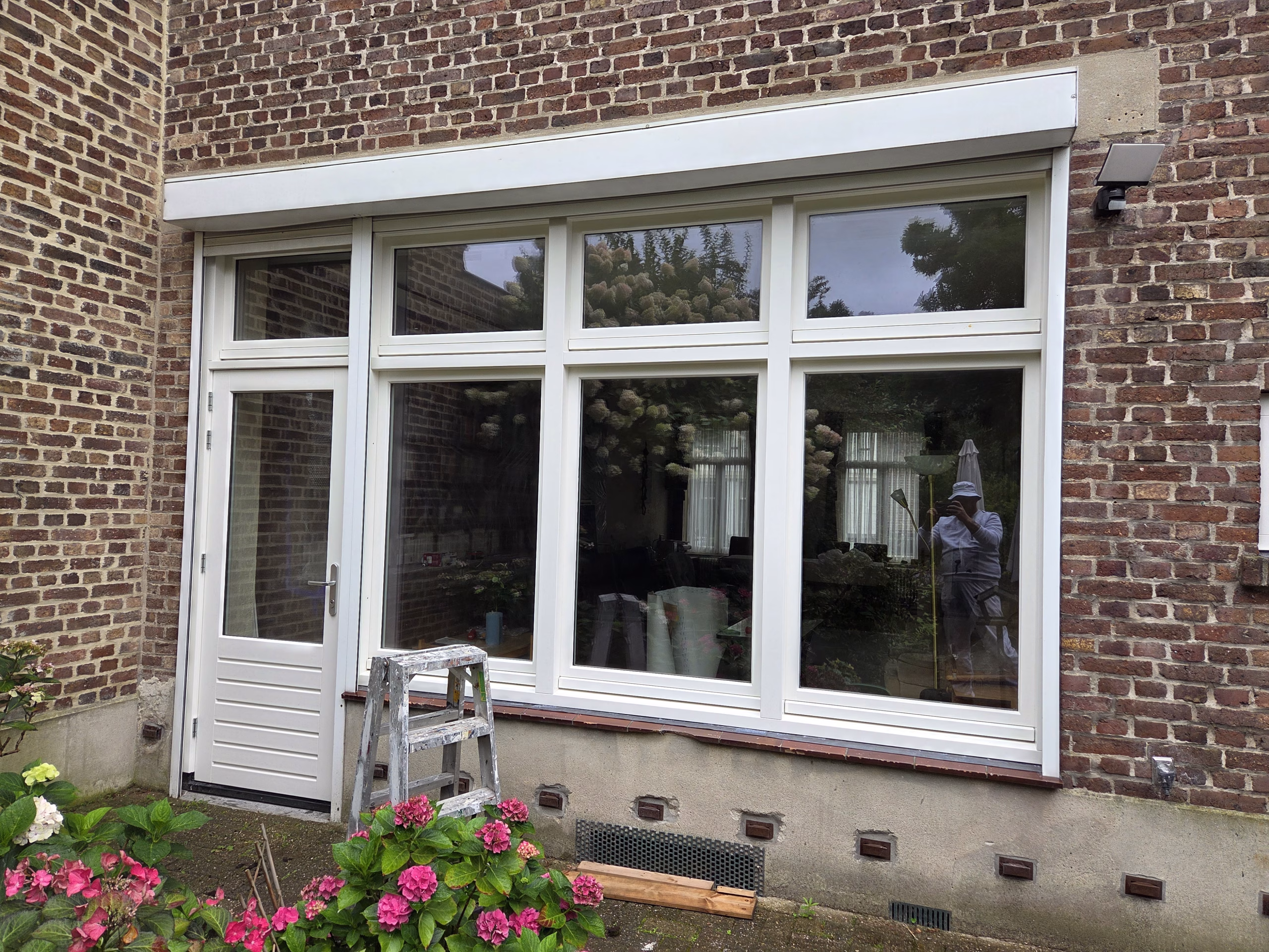 Achtergevel woning in Simpelveld met witte deur en kozijnen na het schilderwerk.